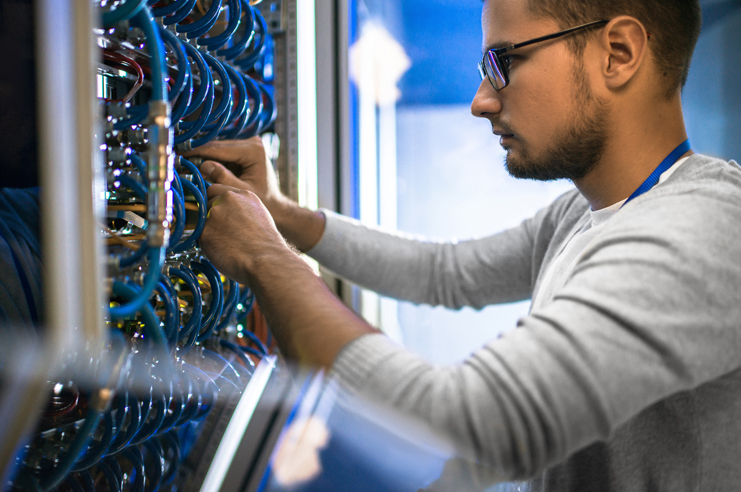 Man working on a network computer rack