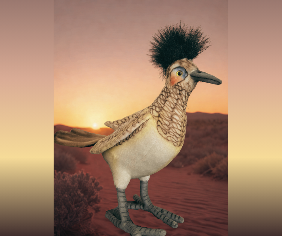 Plushie designed as a roadrunner sitting in a desert landscape with a sunset behind him. It is a photoshopped image.